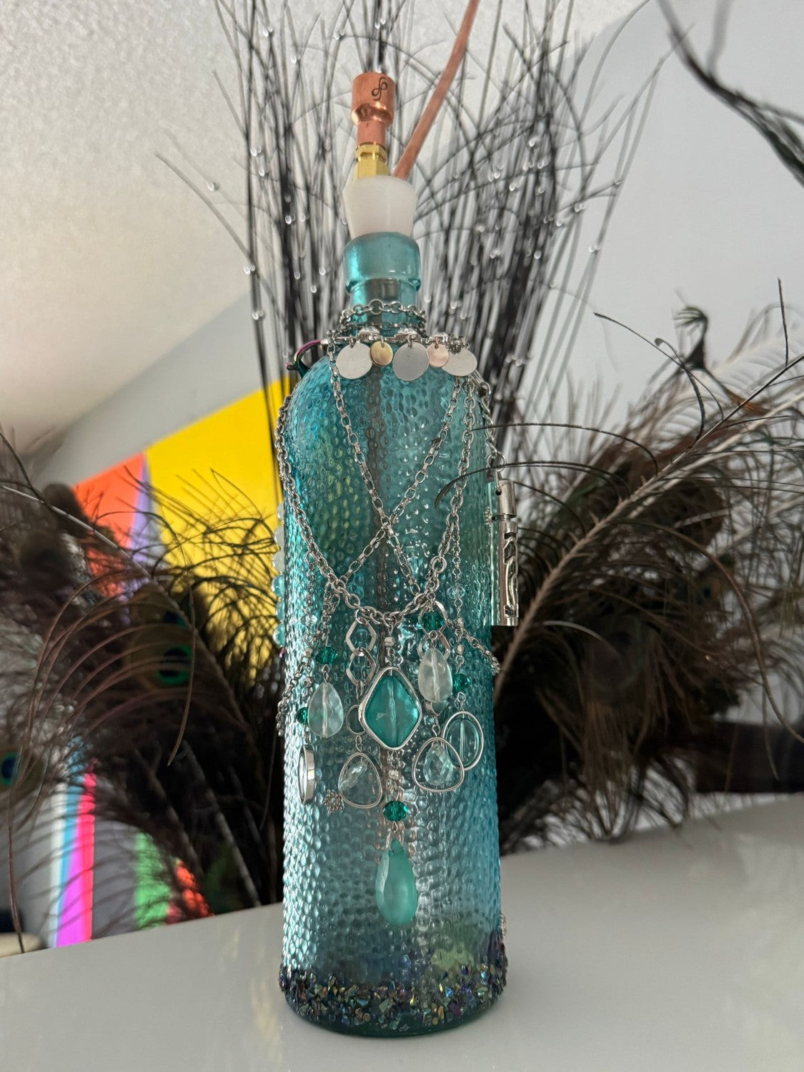 Dressed in silver chains and beads, among the peacock feathers.